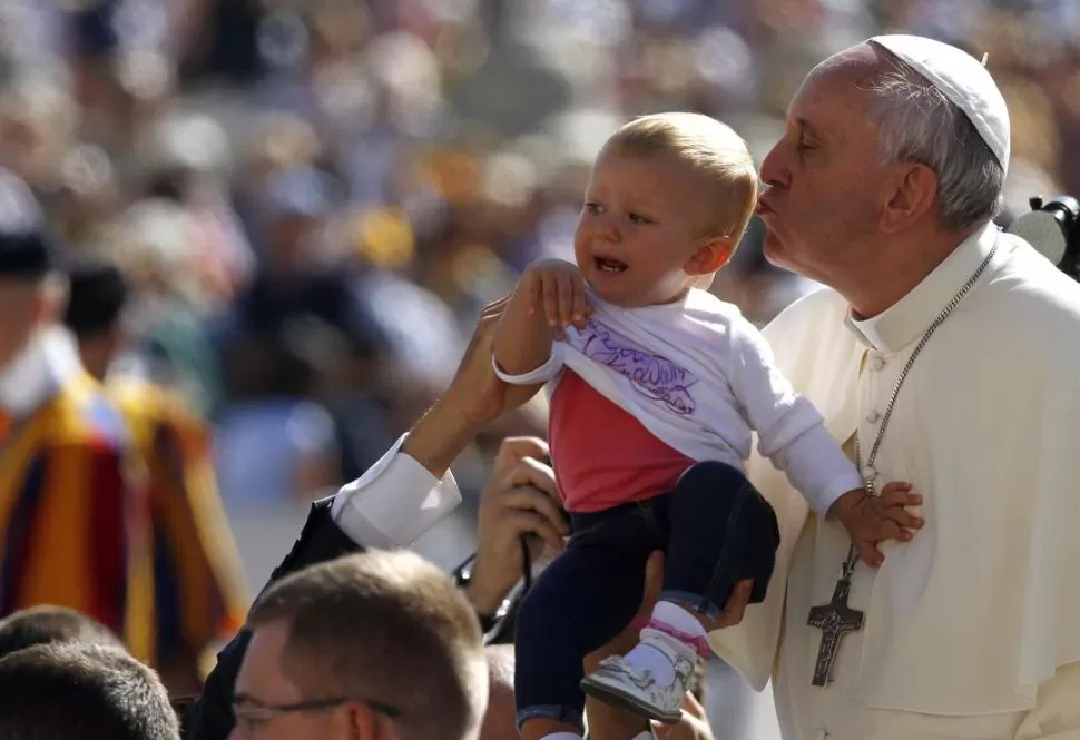 VATICANO. El Papa besa a un niño luego de la audiencia pública.  REUTERS 