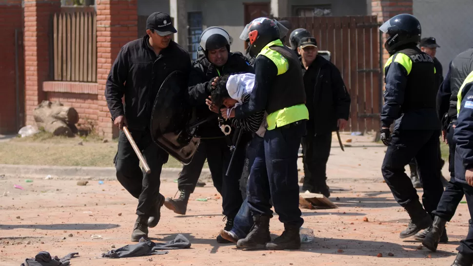 ESPOSADO. Los efectivos policiales rodean a uno de los aprehendidos. LA GACETA / FOTO DE INÉS QUINTEROS ORIO