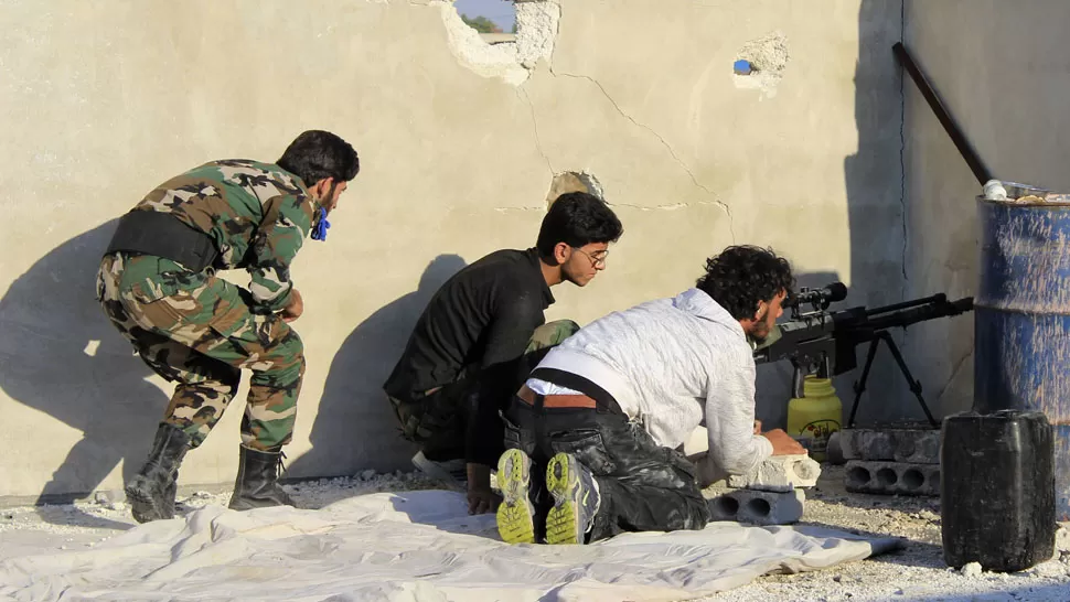 COMBATES. Jóvenes rebeldes enfrentan a las fuerzas de Al Bashar en Alepo. REUTERS