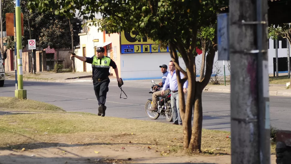 MOMENTO CLAVE. El policía apunta con su arma contra el ladrón, y sostiene la cartera. LA GACETA / JORGE OLMOS SGROSSO