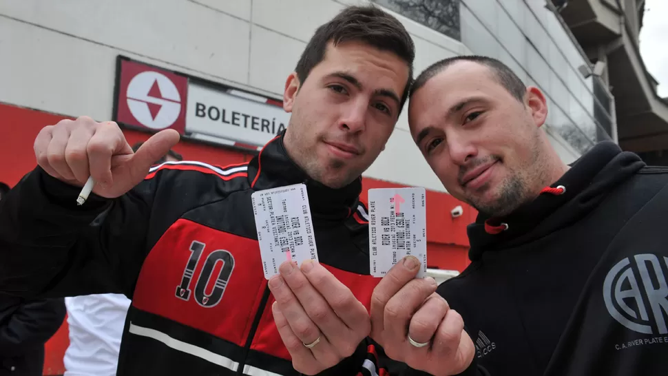 FELICES. Dos hinchas de River muestran sus entradas para el gran partido del fin de semana. DYN