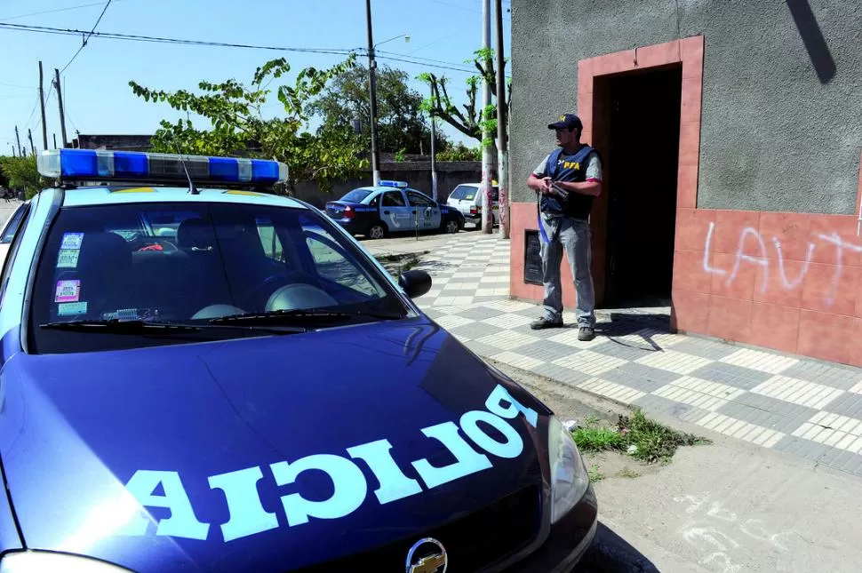 BARRIO AVENIDA. Un policía Federal custodia una casa de San Luis y pasaje Montevideo mientras la allanan. LA GACETA / FOTOS DE JORGE OLMOS SGROSSO