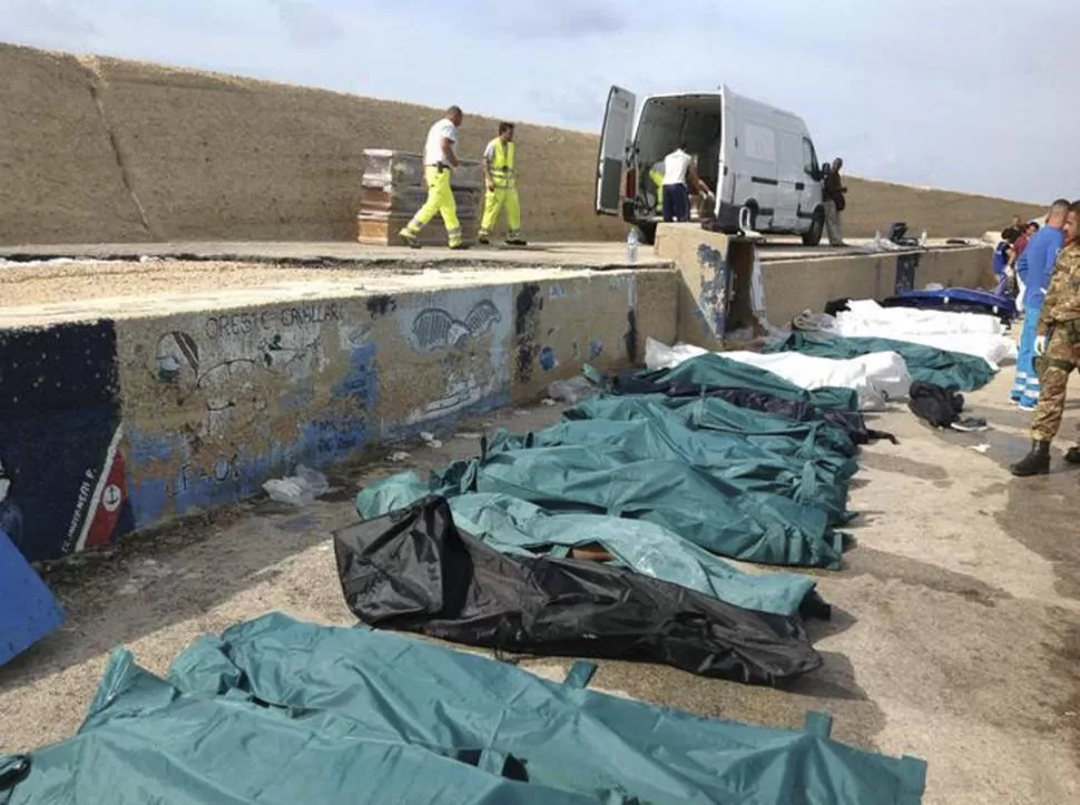  HILERA DEL DOLOR. Decenas de cadáveres, en bolsas de distintos colores, fueron colocados en el muelle de Lampedusa como una morgue improvisada. REUTERS