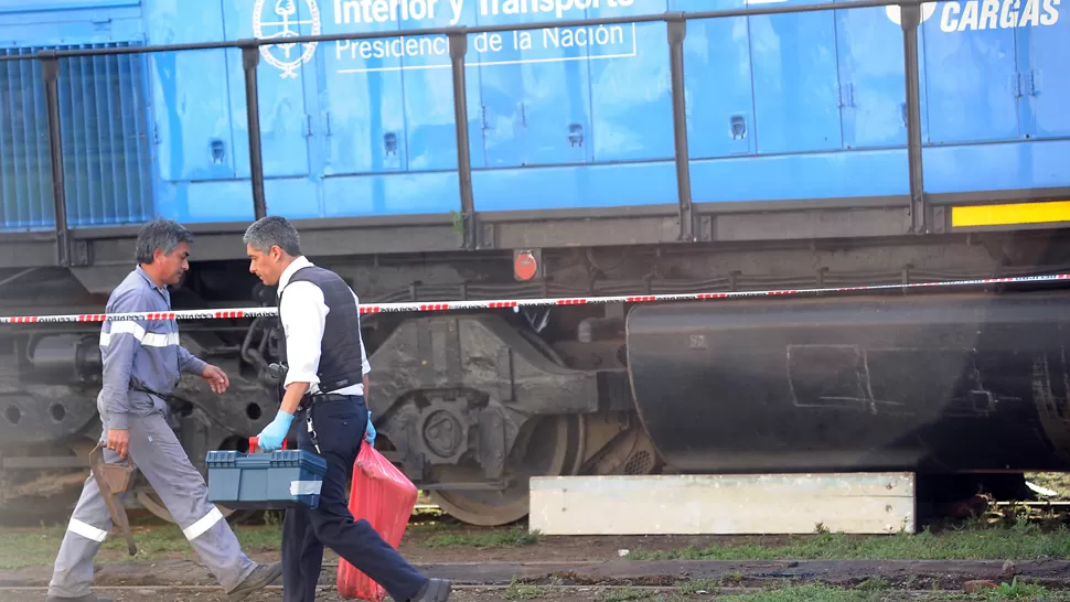 ARDUA TAREA. Trabajaron varias horas para sacar los restos abajo del tren. LA GACETA / FOTO DE HÉCTOR PERALTA