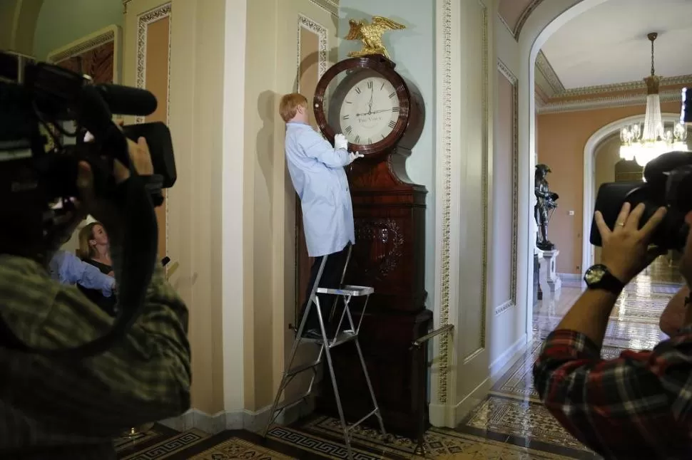 PARÁLISIS. Un empleado hace funcionar el histórico reloj del parlamento de Ohio que había dejado de marcar. REUTERS