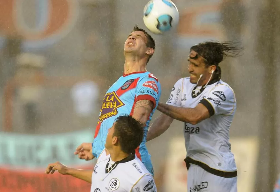BAJO EL AGUA. La incesante lluvia que cayó sobre Buenos Aires, decora el salto de los jugadores durante el partido de ayer. 