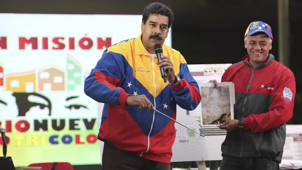 MISTICO. Maduro muestra una foto de la pared del subte de Caracas, en la que aseguran que apareció la imagen de Chávez. REUTERS