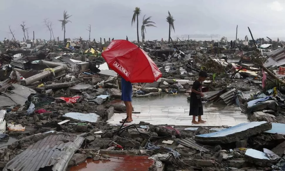 EN MEDIO DE LA NADA. En la ciudad de Tacoblán, centro de Filipinas, una niña observa con su madre lo que quedó de su casa: sólo el piso. Alrededor se repite el daño que causó el tifón. REUTERS