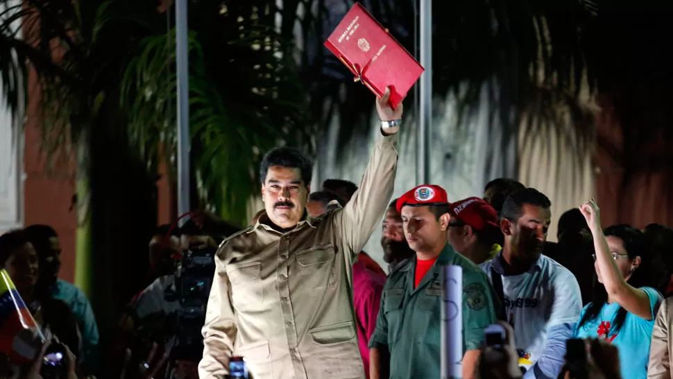 SALUDO. Maduro muestra la ley que le da poderes especiales.  REUTERS