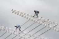 Sin arneses, los obreros avanzan sobre el techo del estadio