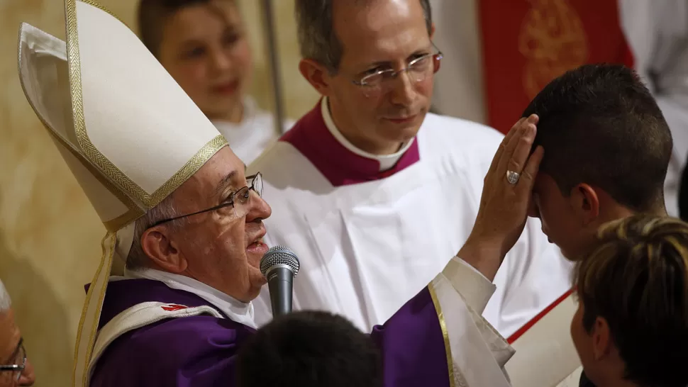 EN UNA PARROQUIA. El Papa le da la bendición a un chico, durante la misa que dio ayer en la iglesia de San Cirilo, en Roma. REUTERS