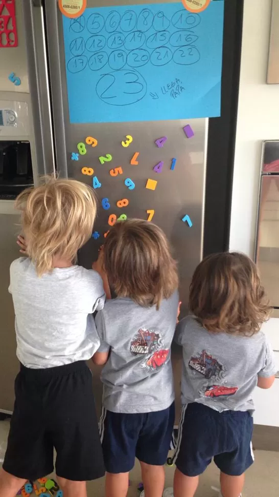 DIVERTIDOS. Los niños juegan con los números en la heladera; arriba, un cartel indica cuándo verán a su padre. FOTO TOMADA DE TWITTER / WANDITANARA