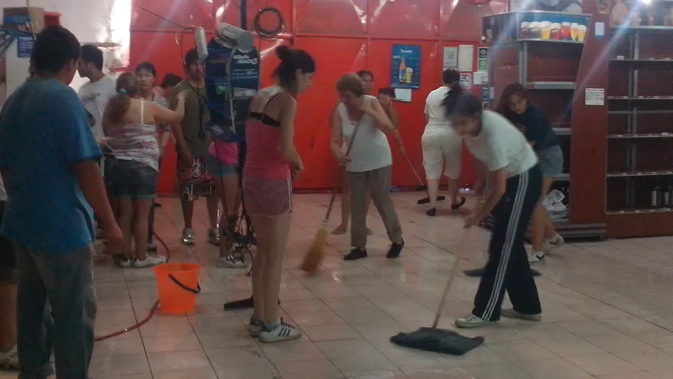 A TRABAJAR. Las mujeres se organizaron en grupos para comenzar la limpieza, hasta sacarle brillo al piso del local comercial. foto gentileza de Maria De Los Angeles Ruiz