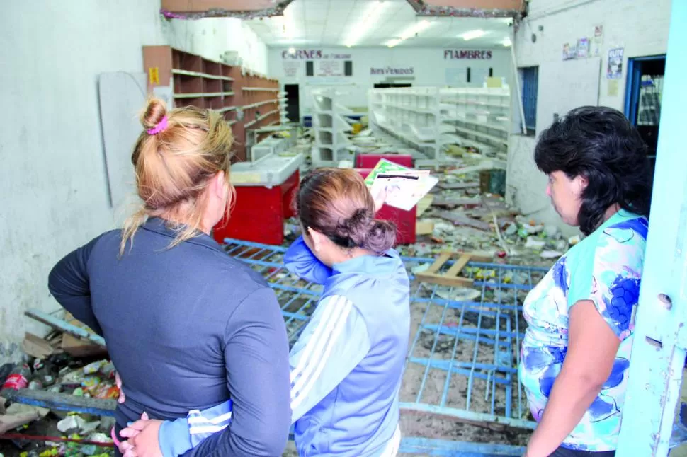 ENSAÑAMIENTO. Celeste Pérez (izquierda) junto a otras compañeras de trabajo observan la destrucción que dejaron los saqueos en el súper “Apolo”. la gaceta / foto de álvaro medina