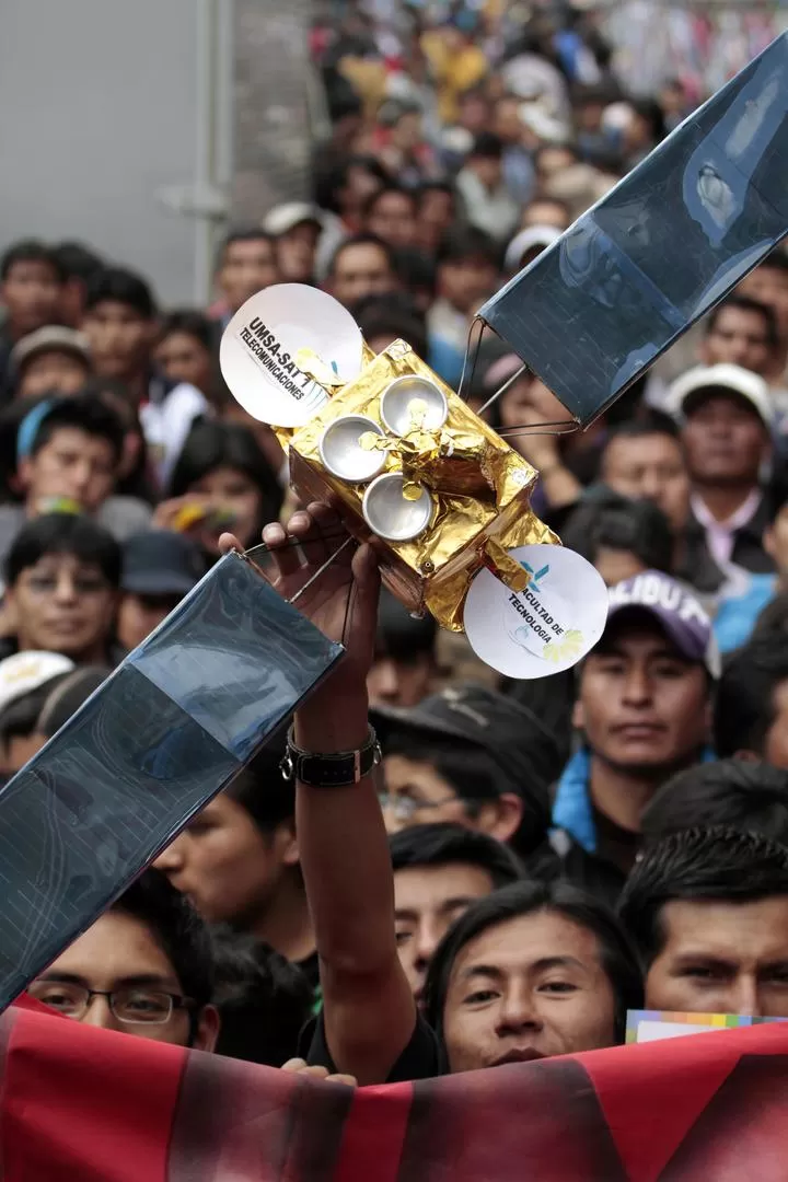 EN LA PAZ. Miles de bolivianos salieron a celebrar el lanzamiento del satélite, cuya réplica exhibe uno de ellos. reuters