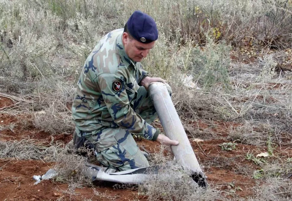 INSPECCIÓN. Soldado libanés revisa la “cáscara” del cohete lanzado a Israel. reuters