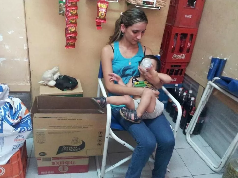 SOLA. Fernanda Avellaneda atiende el drugstore y alimenta a su hijo de un año, a la espera de que su esposo Gabriel Jerez sea liberado. FOTO DE MARIANA ROMERO