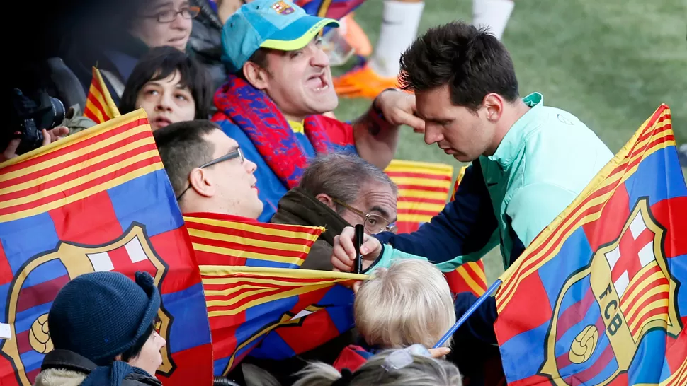 SOLIDARIO. Messi se detuvo a firmar autógrafos a algunos hinchas de Barcelona durante el entrenamiento en Cataluña. REUTERS