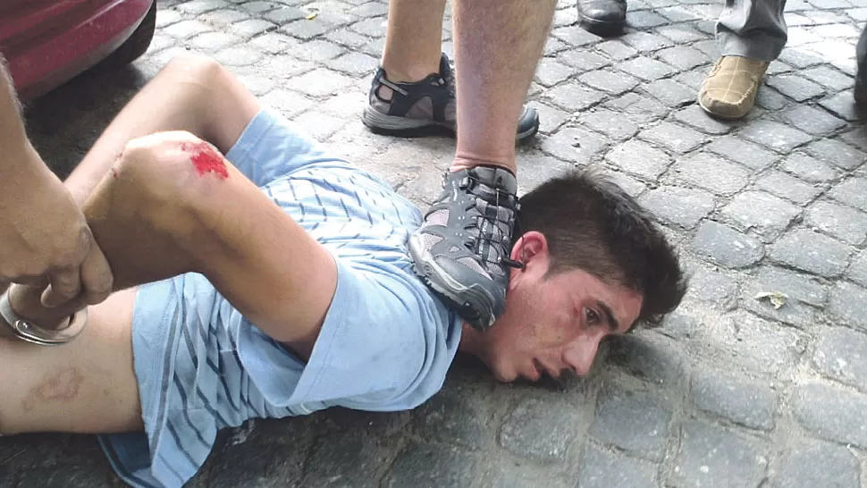 FIN DEL ASALTO. El joven agresor, tras ser atrapado a 30 metros del bar.  FOTO GENTILEZA DE EMILIO DUMIT