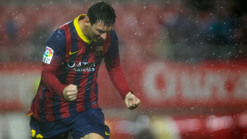 PISA FUERTE. Messi grita eufórico uno de sus tantos bajo la lluvia de Sevilla. REUTERS