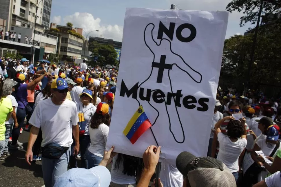 UNA MASIVA PROTESTA. En la marcha de los sectores opositores al Gobierno de Maduro llevaban carteles como el que muestra esta imagen. REUTERS