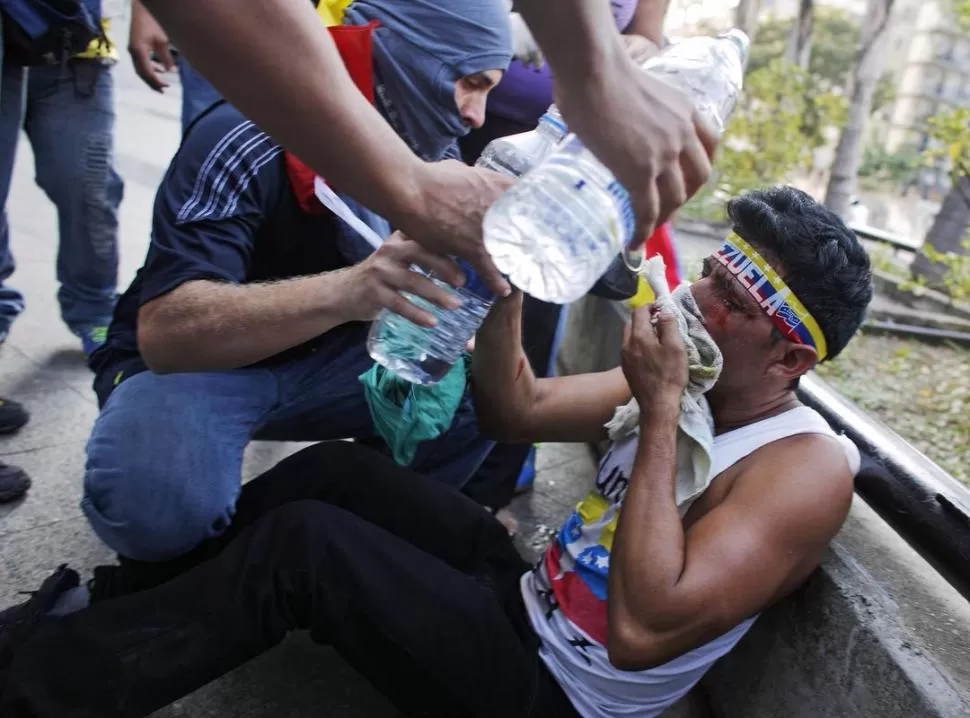 MARCHAS VIOLENTAS. Un manifestante herido es ayudado por otros durante una protesta en Caracas contra el gobierno de Nicolás Maduro. fotos de reuters