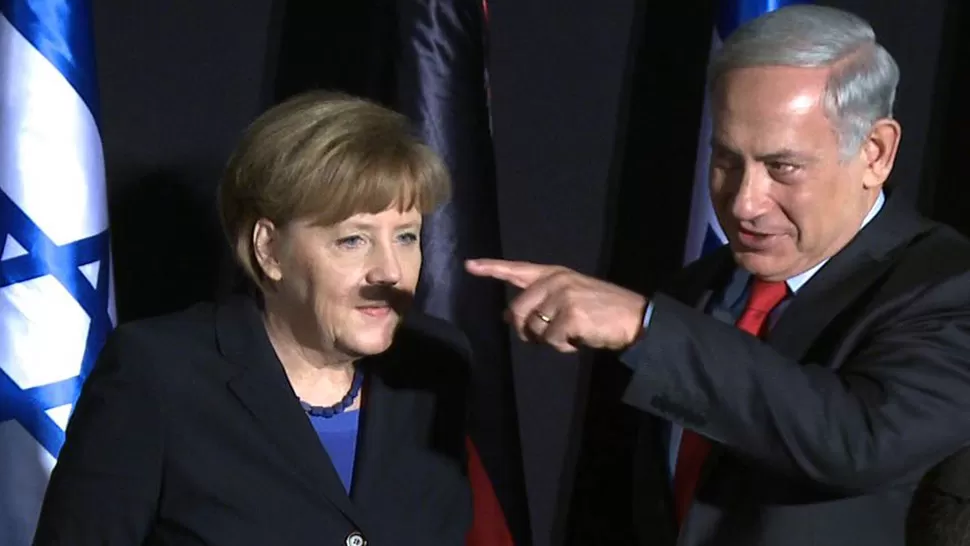 COINCIDENCIA. El dedo proyectó una sombra similar a un bigote sobre el rostro de Merkel. TELAM