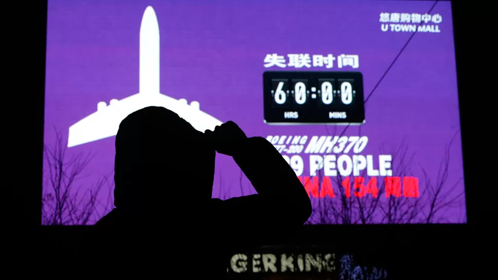 ATENTOS. Una mujer observa el cartel que indica hace cuántas horas desapareció del avión. REUTERS