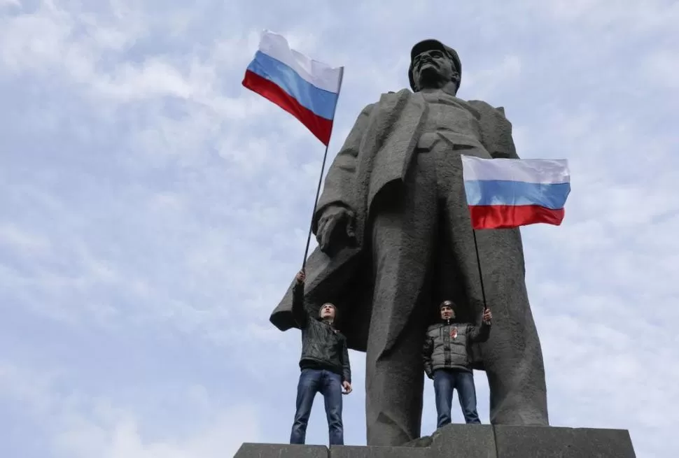 EN DONETSK. Militantes prorrusos posan en la estatua de Lenin. reuters