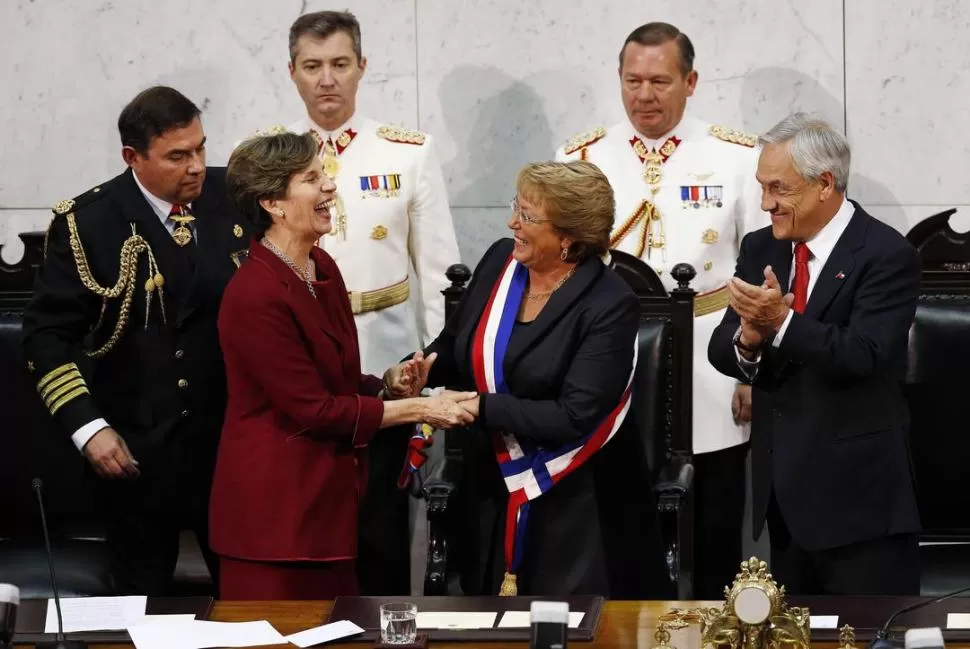 LA INVESTIDURA. La senadora Isabel Allende, presidenta del Senado chileno, saluda a Bachelet luego de tomarle juramento. Sebastián Piñera aplaude. reuters