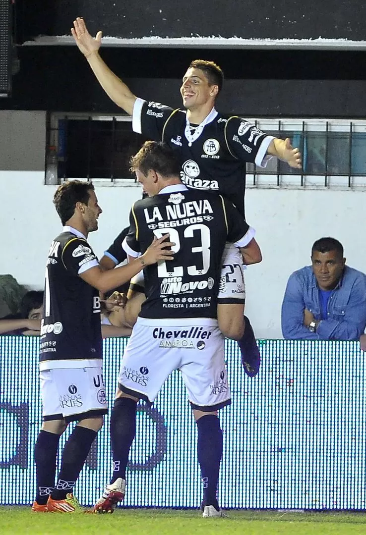 ARRIBA ESE FESTEJO. Calleri se trepa encima de Battion y el abrazo de Torasso para celebrar el tercer tanto del local.  télam