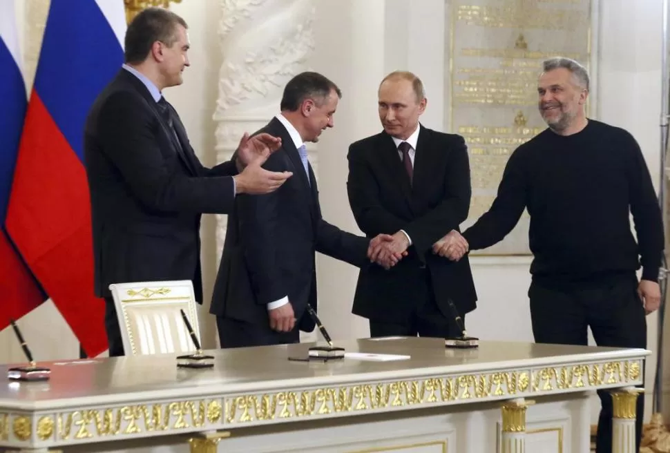EN MOSCÚ. Vladimir Putin saluda a los gobernantes de Crimea, luego de la firma del tratado de integración de la península a la Federación Rusa. reuters 