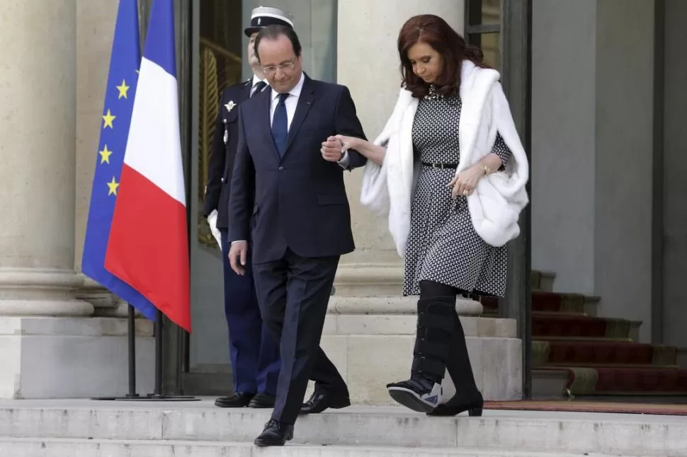 PALACIO DEL ELÍSEO. Hollande ayudó a Cristina -que camina apoyada en la férula en su pie izquierdo- a bajar las escalinatas, cuando se retiraba. REUTERS