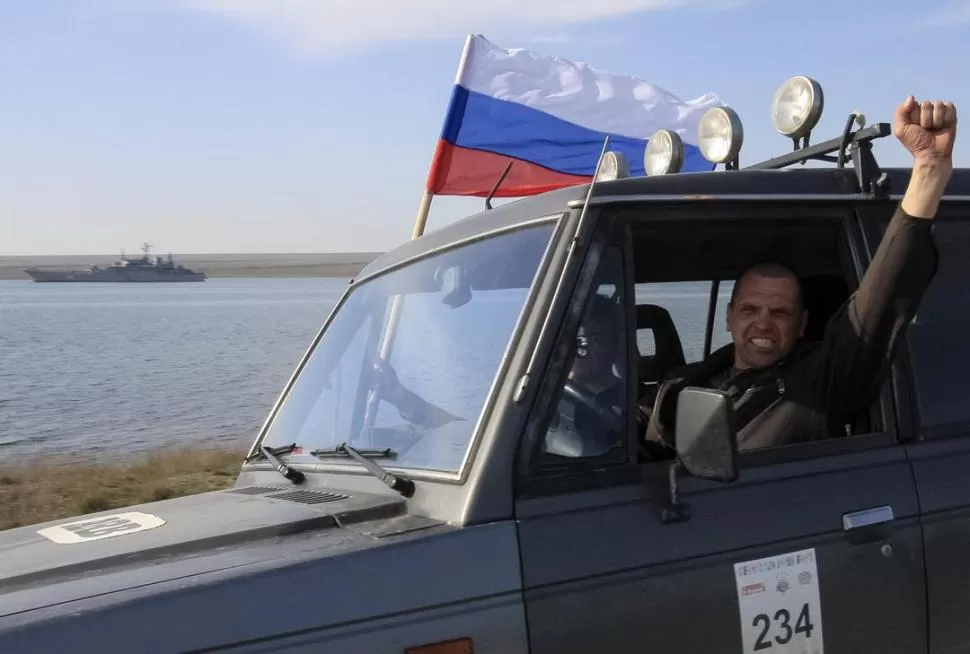 UN TRIUNFO. Un crimeo ondea una bandera rusa, frente a una base militar. reuters