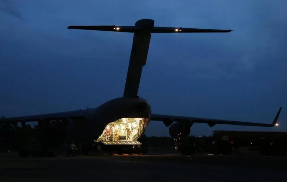 LOGÍSTICA. De un avión de transporte C-17 de la Fuerza Aérea Australiana bajan en Perth equipos que serán utilizados en los operativos de búsqueda. reuters