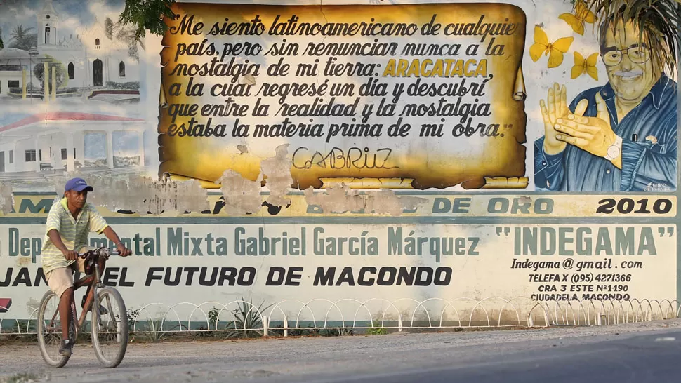 TRANQUILO. Un ciclista pasa por frente a un cartel alegórico a García Márquez, en Aracataca. REUTERS. 
