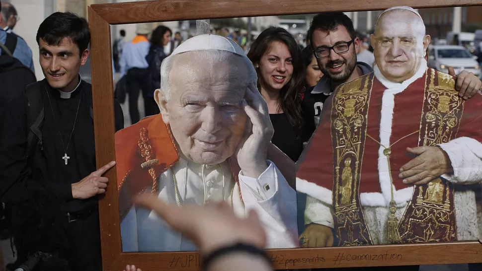 EMOCION. Miles de fieles se concentran en la Plaza de San Pedro para mostrar imágenes de los papas que serán canonizados. REUTERS
