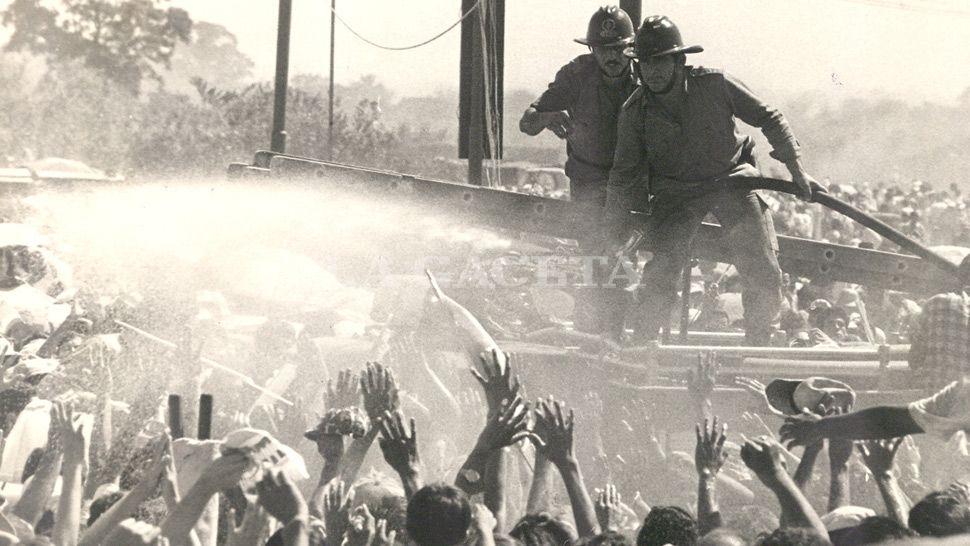 UN POCO DE FRESCO. Los bomberos rocían a la muchedumbre para aplacar el calor.