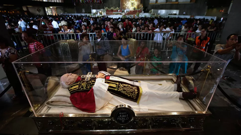 JUAN PABLO II. Los fieles rodean la cápsula que contiene el cuerpo del nuevo santo de la Iglesia Católica. REUTERS