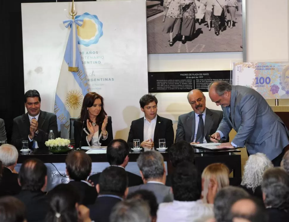 DEUDAS. Cristina Fernández observa al gobernador de Corrientes, Ricardo Colombi, quien firma el convenio de desendeudamiento provincial. telam