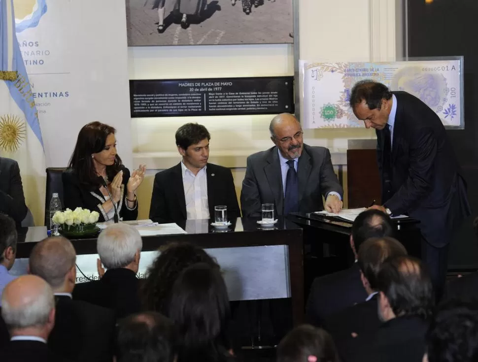 EL MÁS ENDEUDADO. Cristina, Kicillof y Tomada observan a Scioli rubricar el acuerdo fiscal que le dará un respiro a las finanzas de Buenos Aires. dyn