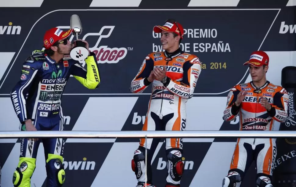 LOS TRES. Márquez aplaude en el podio; Rossi besa la copa y Pedrosa acompaña. 
