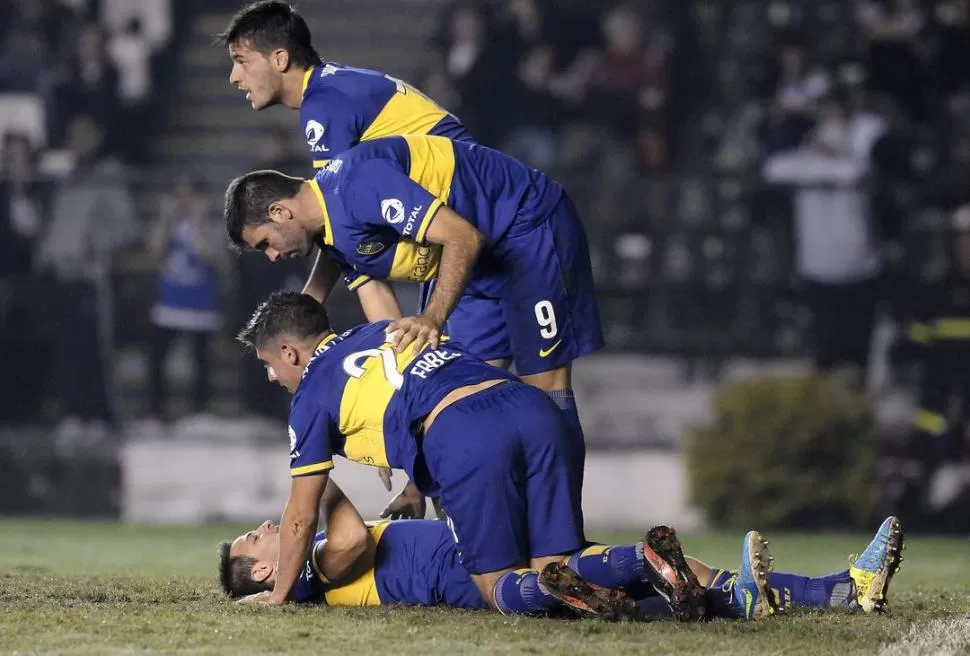 PILA DE FELICIDAD. Insúa, Gigliotti y Erbes se abalanzan sobre Martínez, sobre el piso, que acaba de marcar el primer gol.   dyn