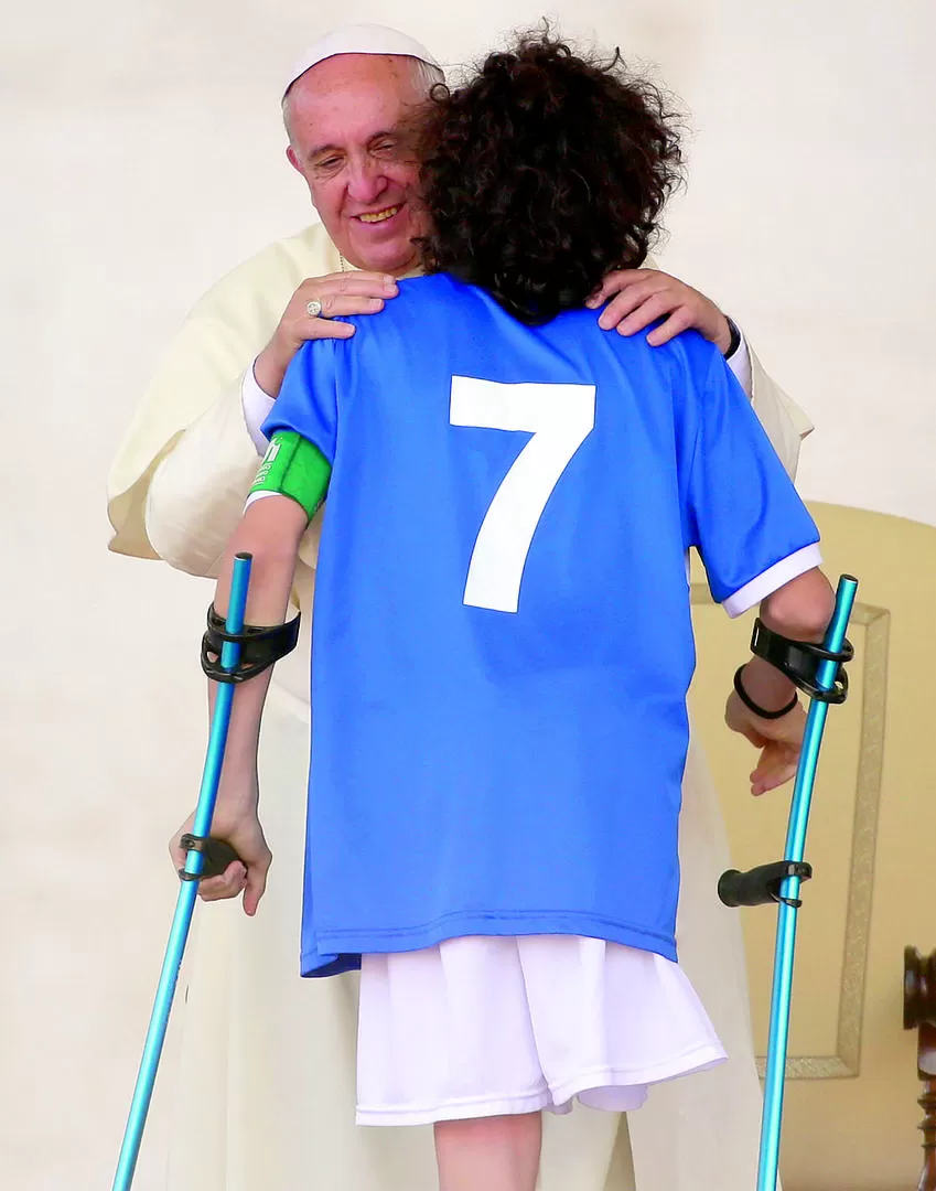 AUDIENCIA ESPECIAL. El Papa saluda a uno de los integrantes de la selección nacional de fútbol italiano de jugadores amputados. reuters