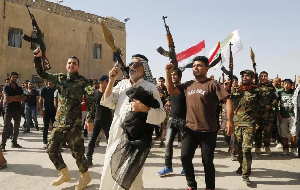 DESFILE. Los voluntarios iraquíes festejan la entrega de armas, en Bagdad. reuters