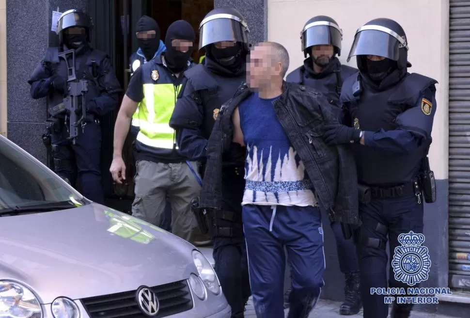 EN MADRID. Policías españoles llevan detenido a César Rodríguez, uno de los nueve individuos sindicados como combatientes yihadistas. reuters