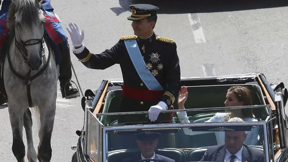 SIN DESCANSO. Felipe saludó, de pie, durante todo el trayecto desde el Parlamento hasta el Palacio Real. REUTERS