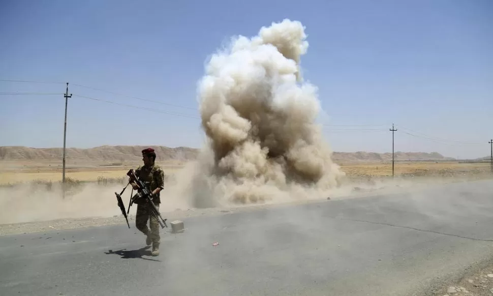 AL NORTE DE BAGDAD. Un soldado kurdo se aleja de una explosión. reuters