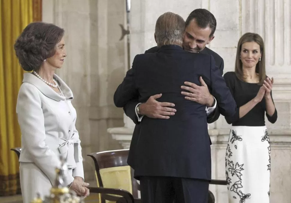 TODO EMOCIÓN. Juan Carlos abraza a su hijo, tras la firma de la ley de abdicación. Sofía observa y Letizia aplaude. fotos de reuters