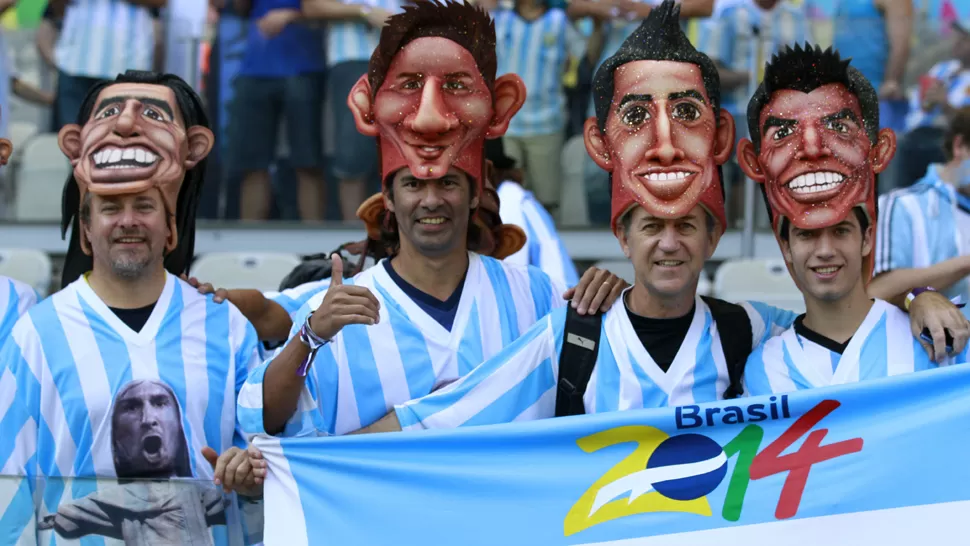 CREATIVIDAD. Un grupo de argentinos llevó máscaras de ídolos argentinos. DYN Y REUTERS
